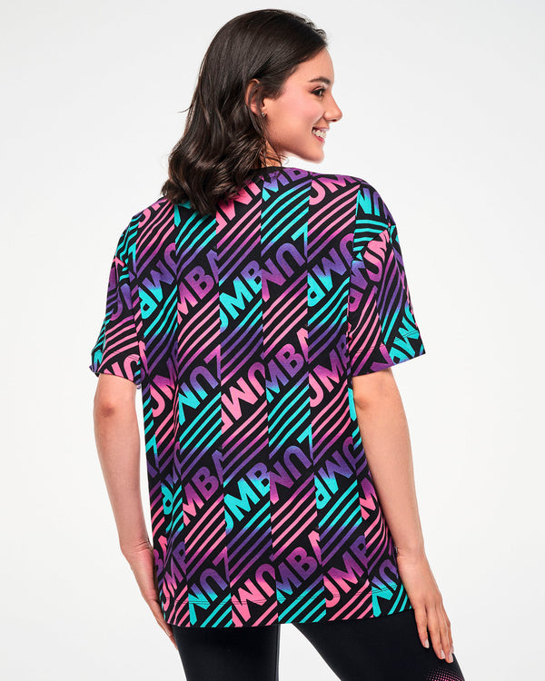 Shown from the back, female model wearing a black tee with a colorful pink, aqua, and purple diagonal striped