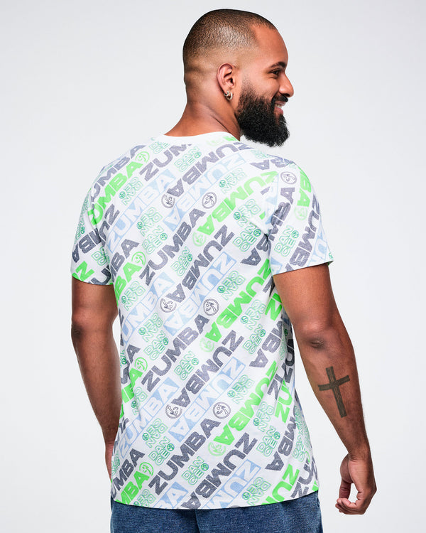 Back view of a male model wearing a Zumba tee with a blue and green 'ZUMBA' logo pattern on a white background.