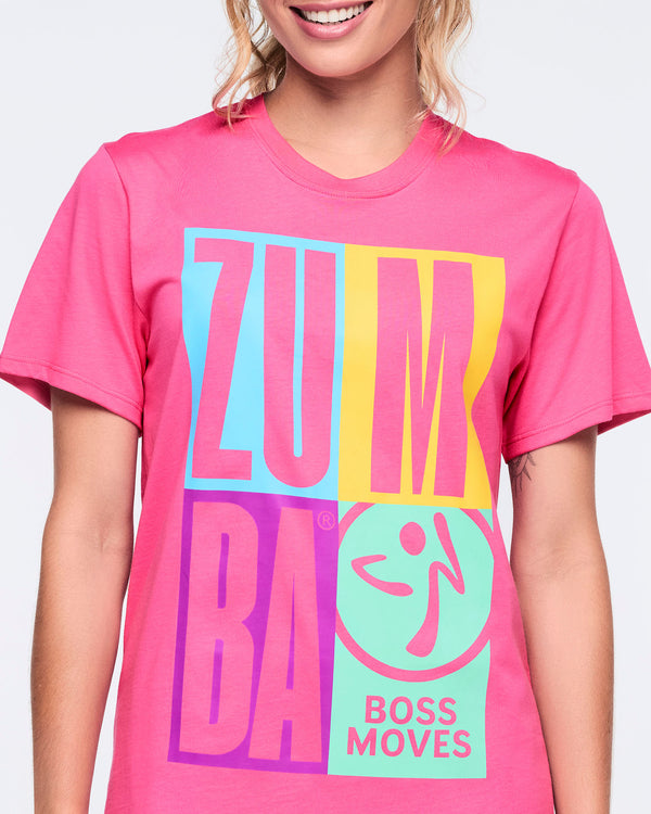 Close-up of the bright pink crewneck Zumba T-shirt showing the large color-block “ZUMBA” front print with a mint Zumba logo and “BOSS MOVES” text.