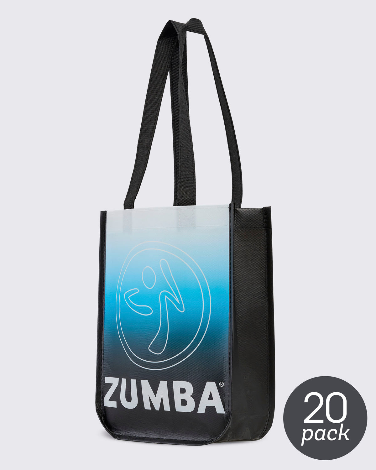 20 pack bag - Reusable black tote with black woven handles, turned to show its front panel fading from white at the top through light blue to black, with a large white outline Zumbito and bold white 'ZUMBA' text beside the black side gusset. 20 pack round sticker in grey in the lower right corner.