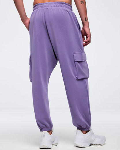 Lilac cargo jogger pants with an elastic high-rise waistband and gathered ankle cuffs, shown from the back on a female model wearing white low-top sneakers.