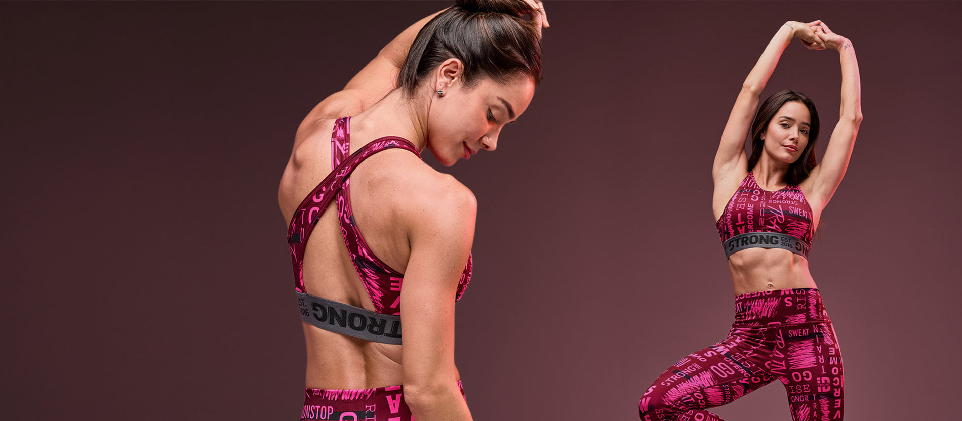 Banner featuring two views of a female model in a pink graphic workout set against a mauve studio background. She wears a matching sports bra and high-waisted leggings covered in bold pink text with a wide black elastic under-band on the bra that reads “STRONG. Est. 2016” One view highlights the open-back cross strap design, while the other shows the full coordinated set as she stretches with arms raised.