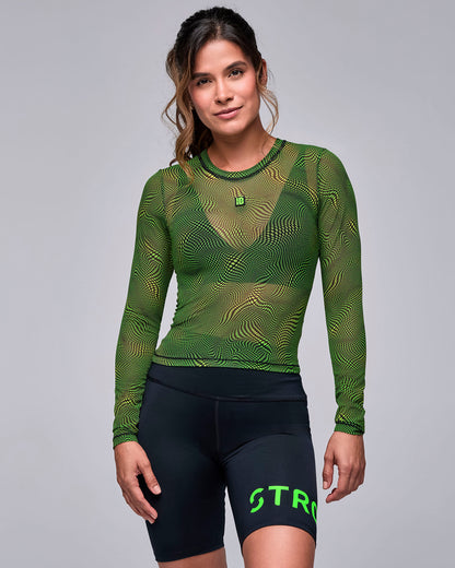 Neon green and black wavy check print sheer mesh long sleeve top on a female model, worn over a black bra, with black 'STRONG iD' biker shorts.