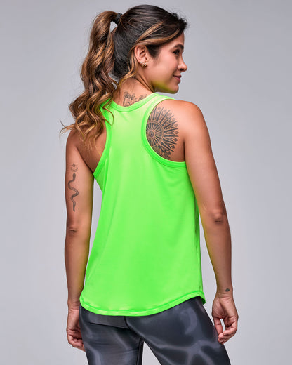 Shown from the back, the neon green 'STRONG' basketball tank with a racerback and plain back, over black and grey swirl print leggings.