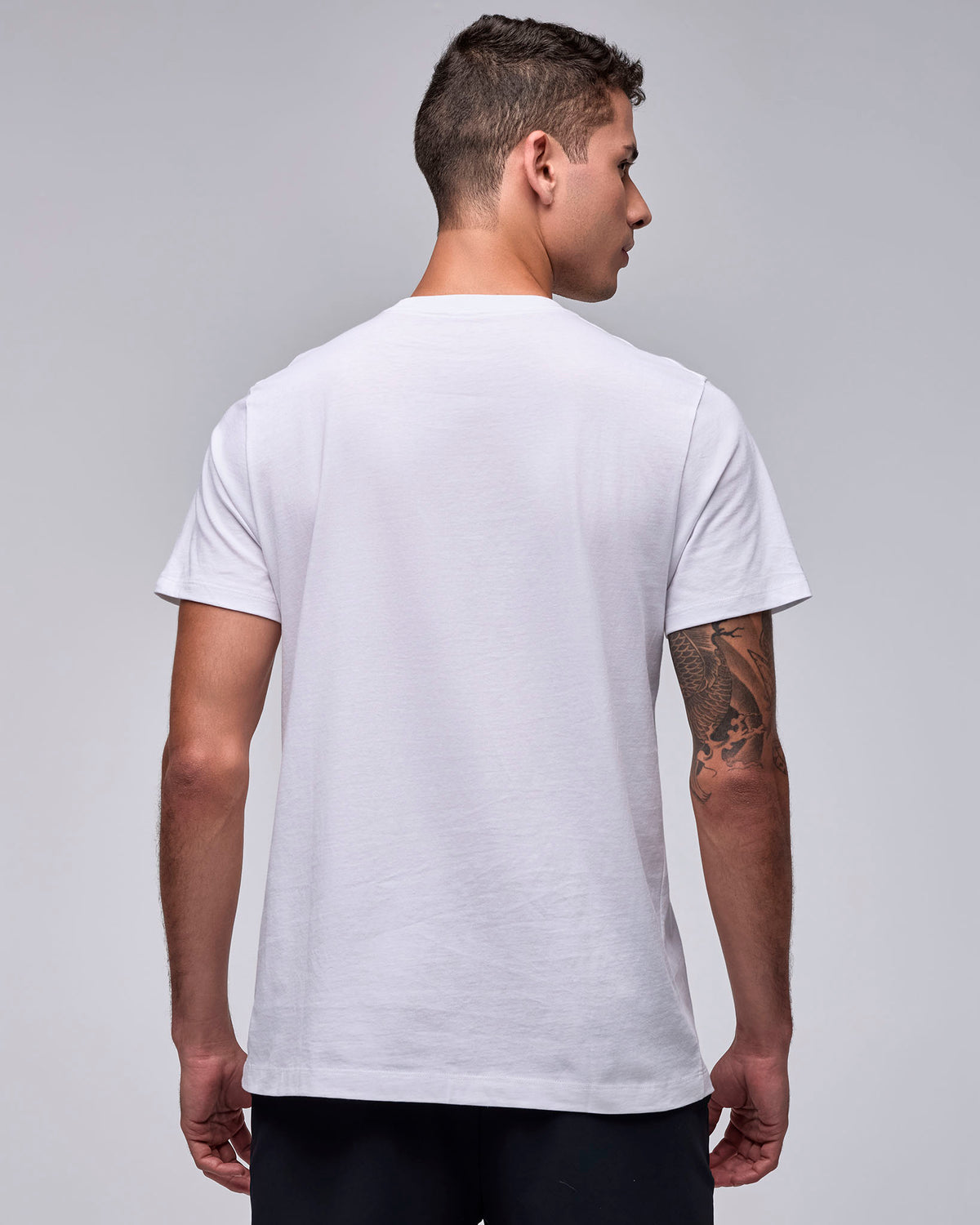 Shown from the back, the white 'STRONG iD' graphic tee on a male model, with a plain back and short sleeves.