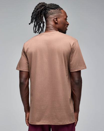 Taupe short-sleeve T-shirt with a plain back, shown from the back on a male model wearing burgundy athletic shorts against a light gray studio background.