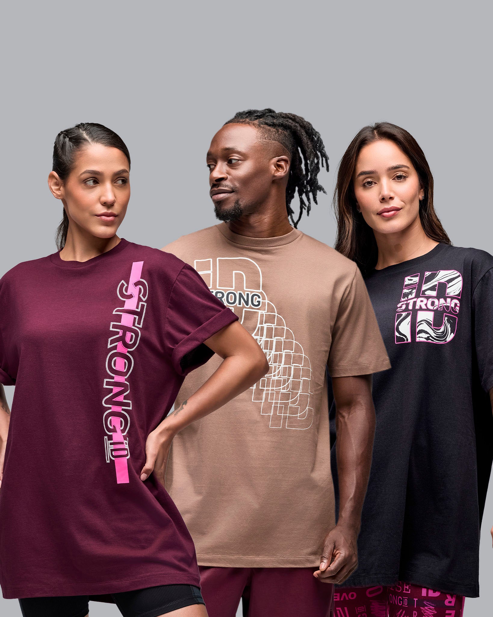 Assorted oversized graphic T-shirts in burgundy, taupe, and black, shown on two female models and one male model against a light gray studio background.