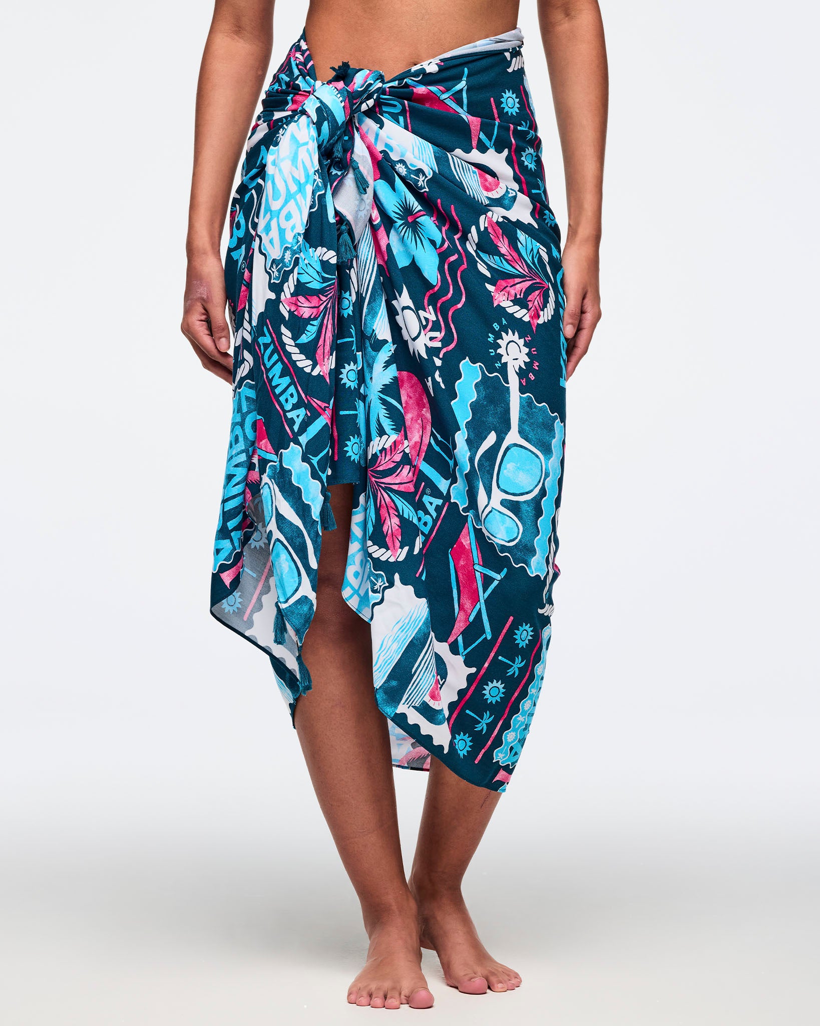 Navy sarong wrap skirt with teal, white, and hot-pink Zumba tropical print, tied in a front knot with an asymmetrical midi hem; shown on a female model.