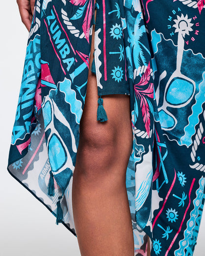 Close-up of the navy Zumba sarong tie detail showing the front knot, tassel ends, and bold teal-and-pink tropical graphic print.