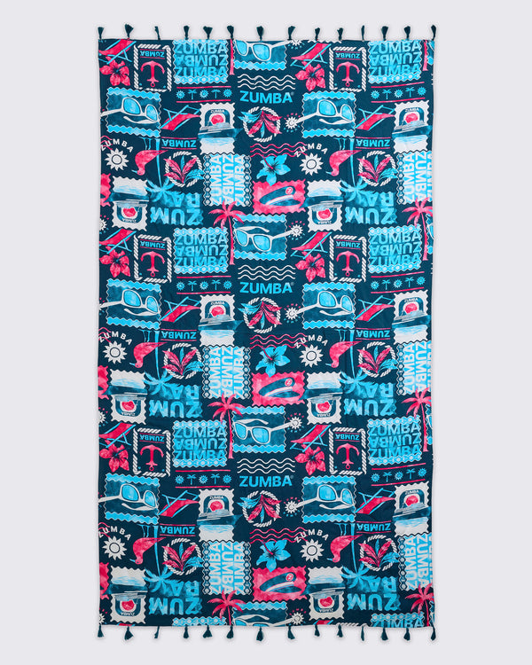 Navy Zumba beach blanket or towel with tassel trim and an allover teal-and-pink tropical collage print featuring sunglasses, flowers, waves, and logos, laid flat.