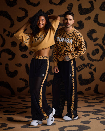Female and male models wear mustard leopard-print Zumba tops, black mesh pants with side stripes, and white sneakers.