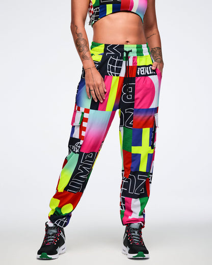 Female model wearing colorful, patterned pants on a white background.