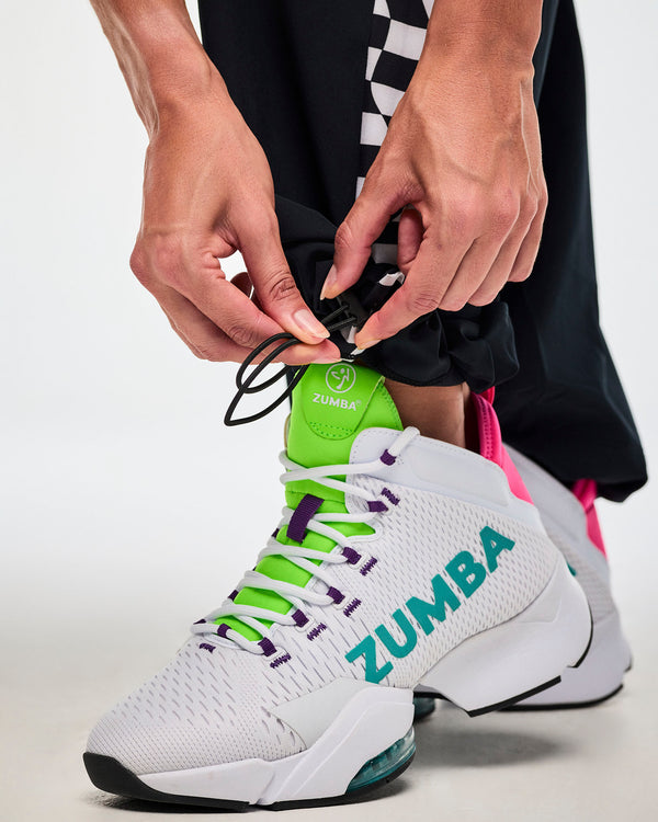 Close-up of a female model adjusting the bungee cords at the bottom leg opening and showing the white 