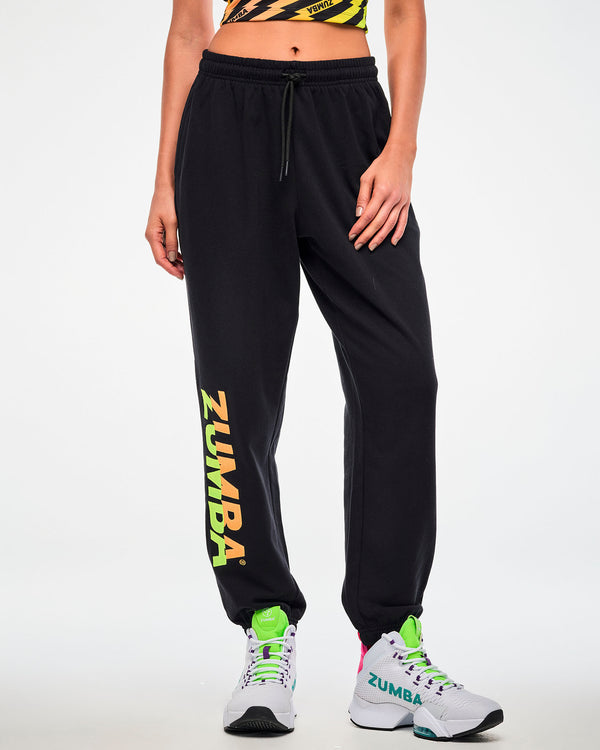 Close-up of a female model wearing black joggers with a green-to-orange gradient 