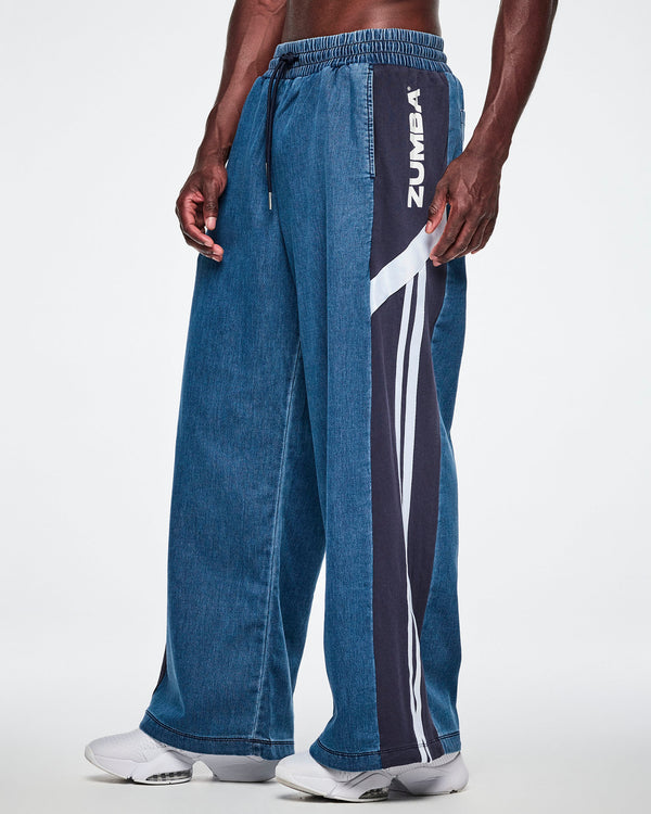 Close-up front view of a male model wearing wide-leg combo pants, showing the navy side panel with white 