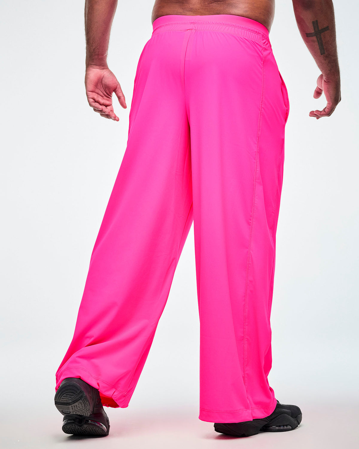 Back view of pink slouch pants worn by a male model, showing the elastic waistband against a white background.