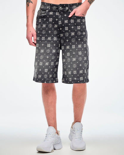 Male model wearing black denim jorts with one hand in the front pocket and featuring patterned ZW, “01,” stars, dots, and Zumbito motifs, paired with white shoes.