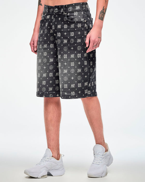 Male model wearing black denim jorts featuring patterned ZW, “01,” stars, dots, and Zumbito motifs, paired with white shoes.