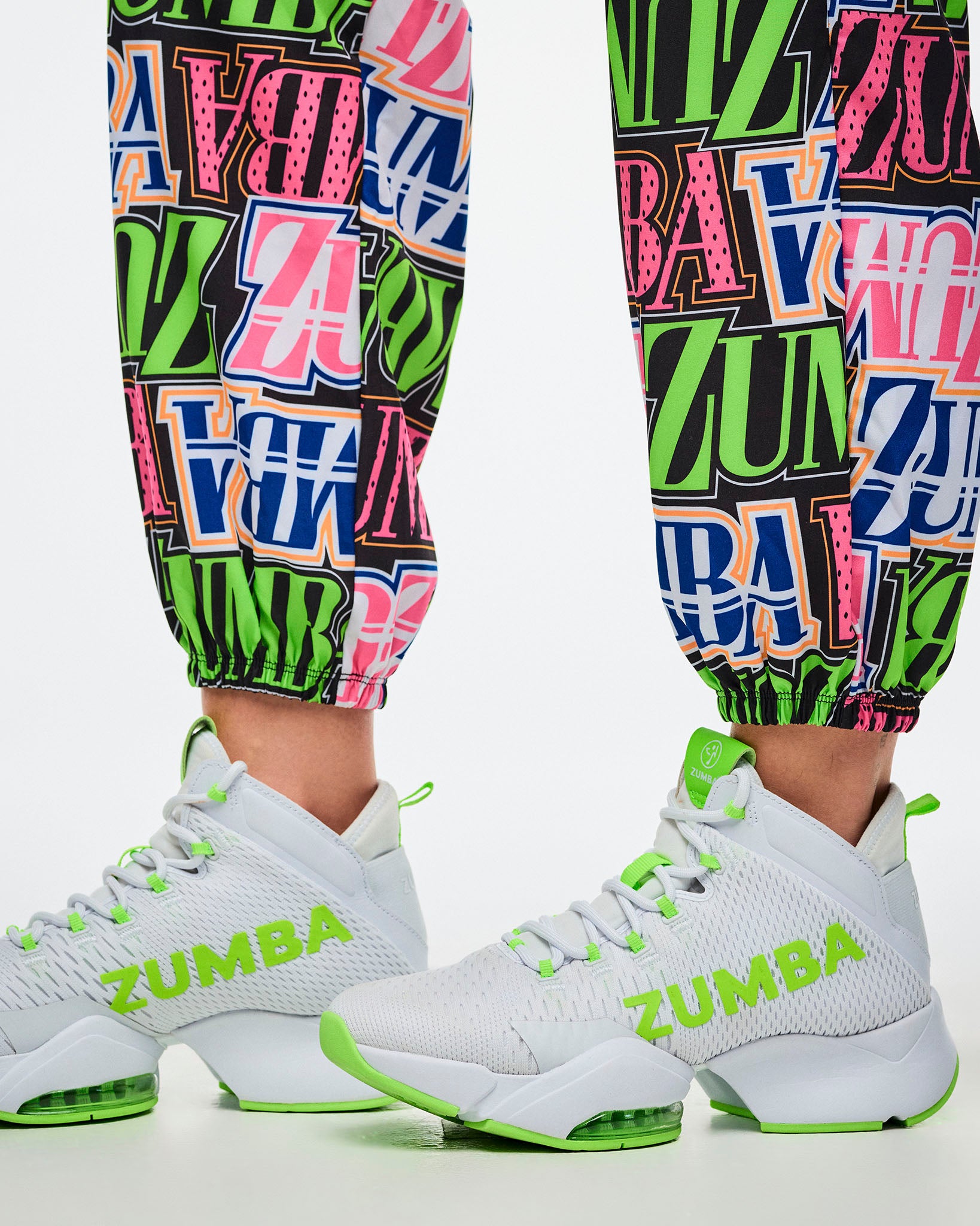 Close-up of encased elastic cuffs on multi-colored Zumba pants, paired with green-and-white shoes.