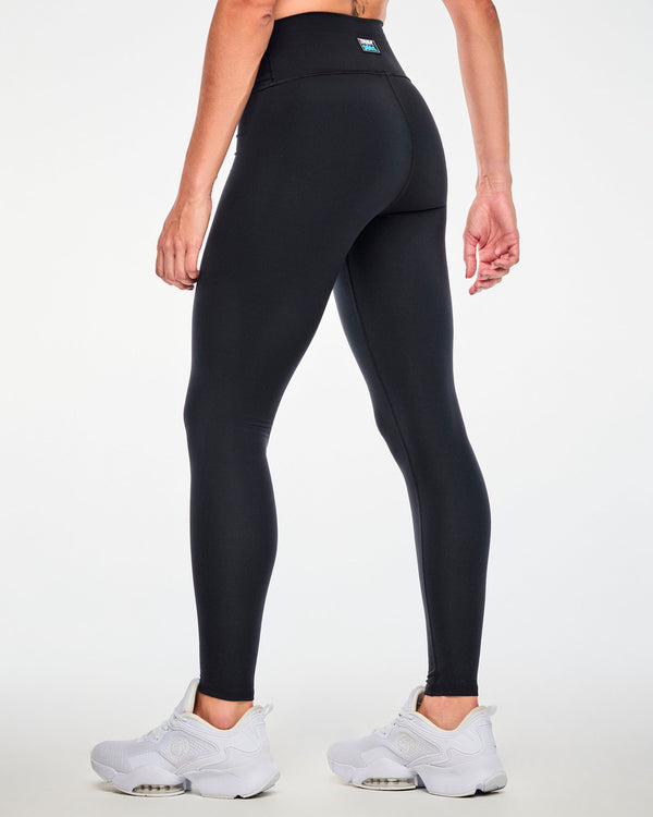 Back view of a female model in the black leggings, showing a plain back and a small 'ZUMBA' and 'THE SMURFS' patch on the back of the waistband.