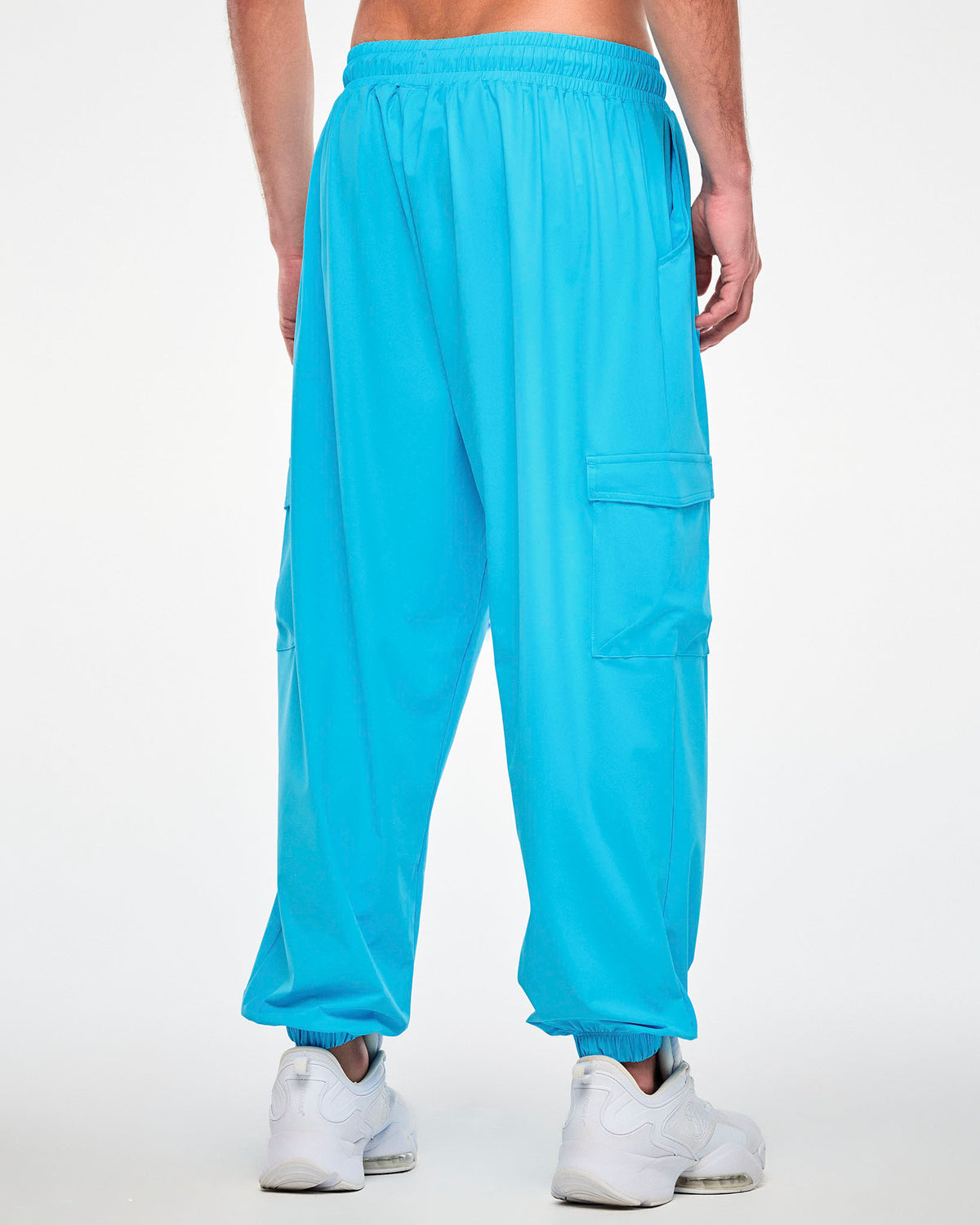 Back view of a male model in the aqua blue cargo pants, showing the gathered elastic waistband, a plain back, and a cargo pocket on each leg.