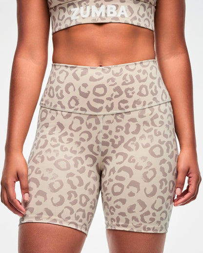Close-up of a female model in beige leopard print high-waisted biker shorts, showing the wide waistband and center front seam, paired with a matching bra.