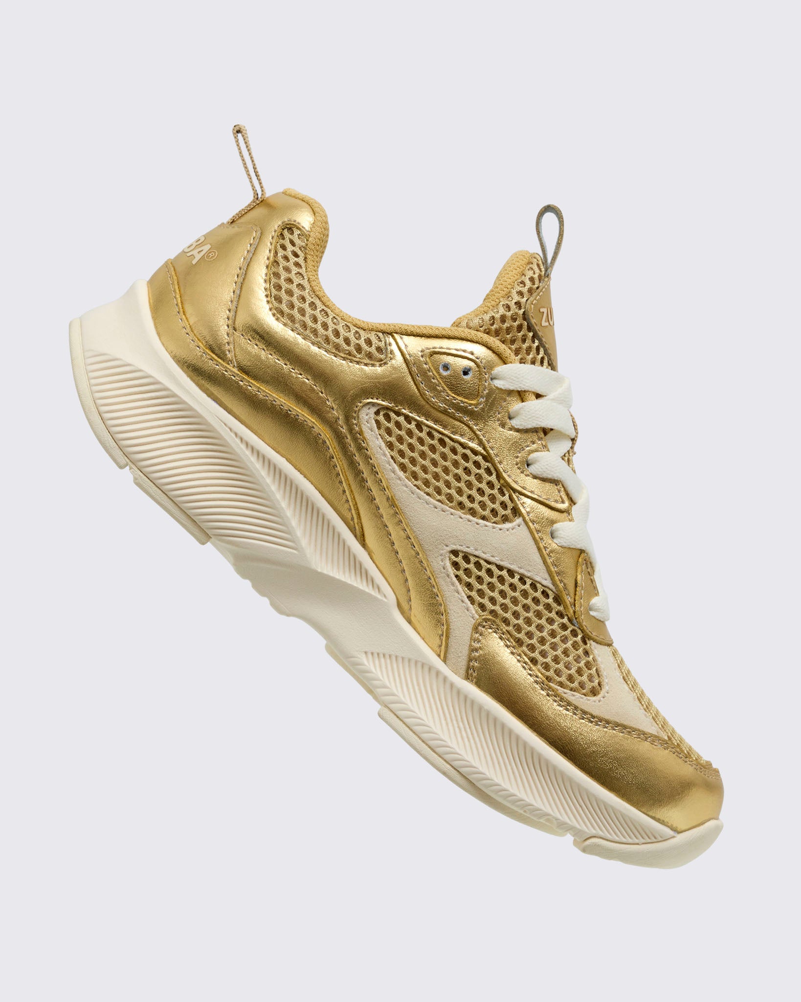 Side angled view of the gold Zumba shoe with laces and back pull tab on a light background.