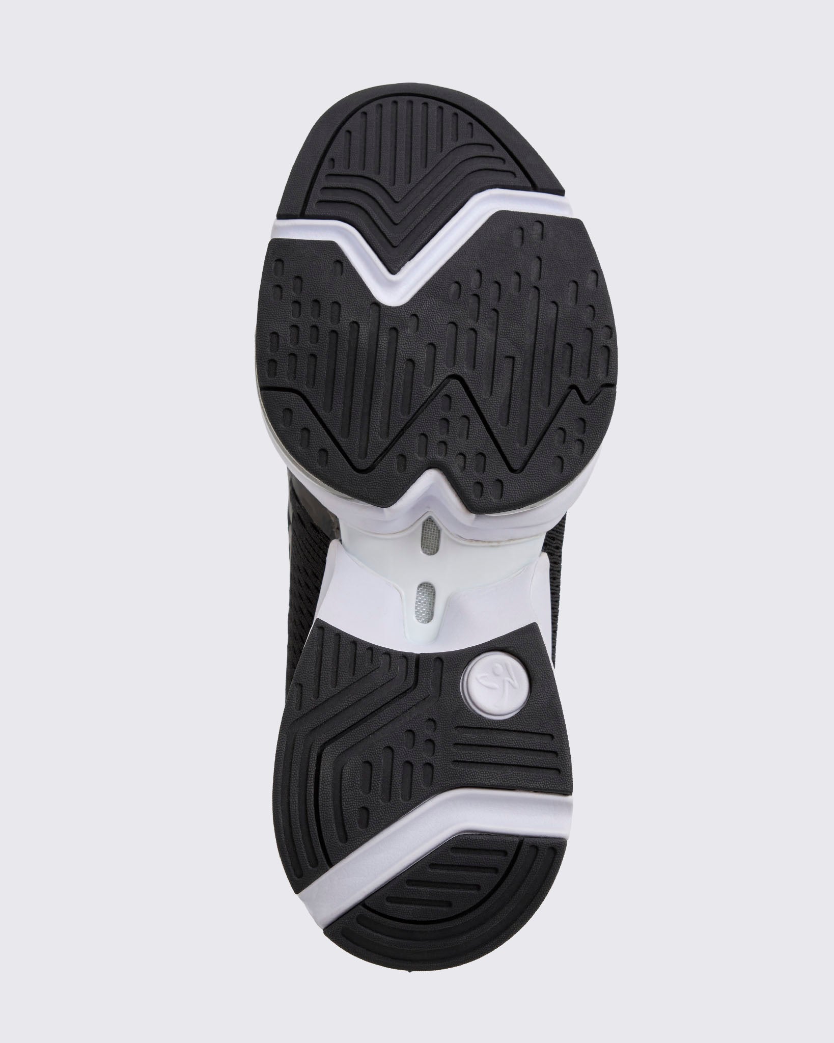 Black Zumba sneaker outsole view, highlighting the full tread pattern, pivot-friendly grooves, and black-and-white split sole construction.