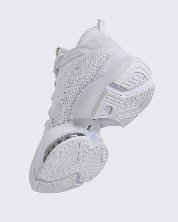 White Zumba high-top athletic sneaker shown from the bottom angle, highlighting the textured outsole tread, split sole design, and visible air cushioning under the mid foot.