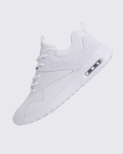 White Zumba low-top athletic sneaker shown in a side angle, featuring a breathable mesh upper, tonal lace-up closure, embossed Zumba logo, and chunky white sole with visible air cushioning.