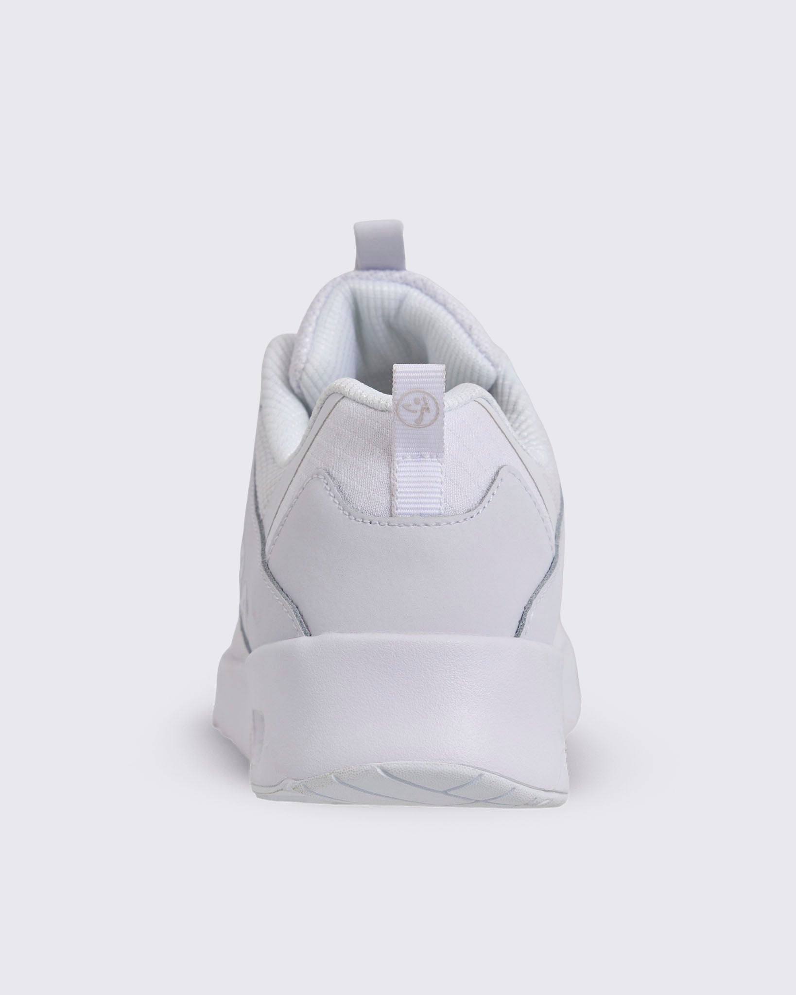 White Zumba low-top athletic sneaker shown from the back, featuring a padded collar, heel pull tab, smooth heel overlay, and chunky white sole.