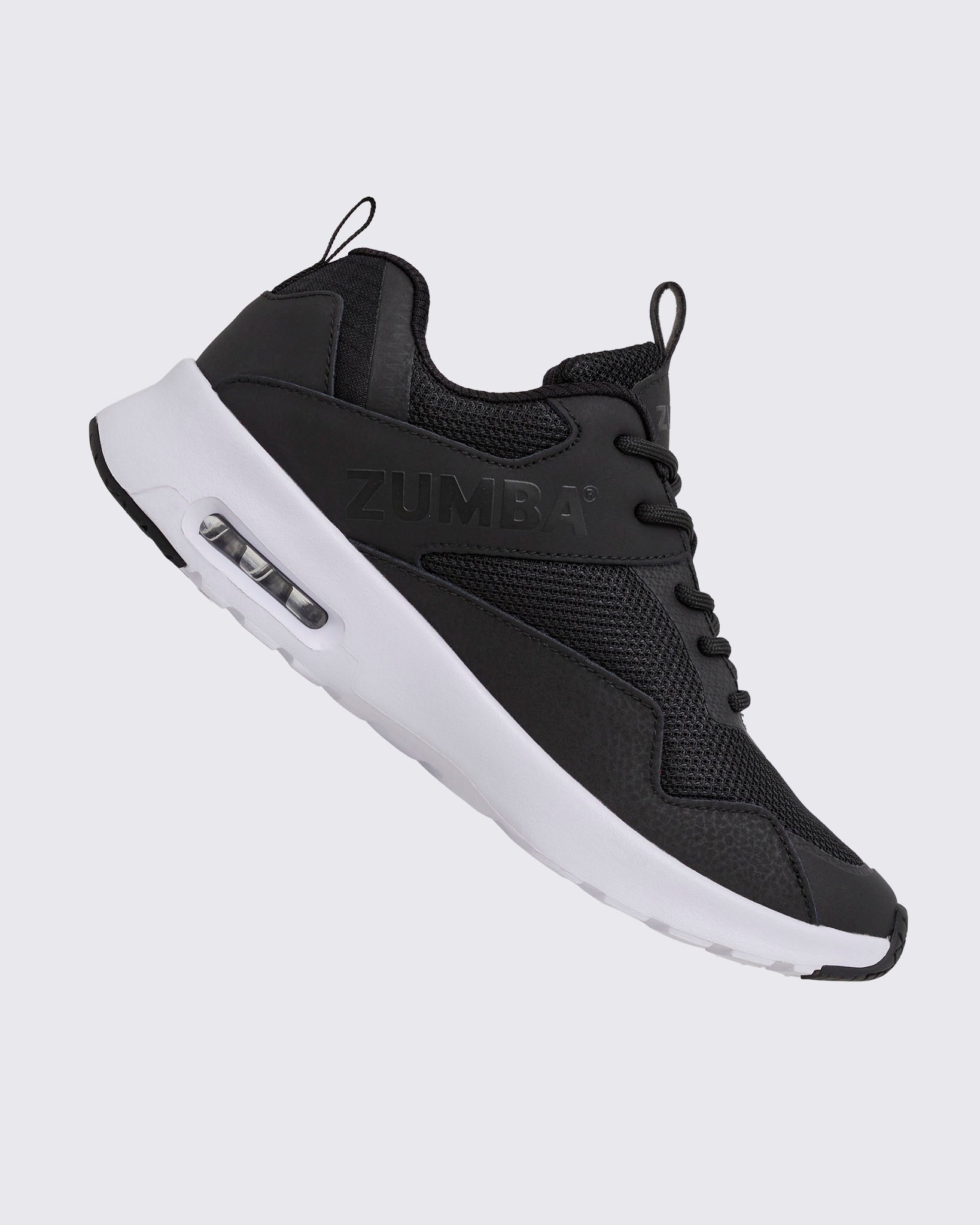 Black Zumba low-top athletic sneaker shown from the opposite side, with textured mesh panels, black laces, embossed side logo, and a thick white sole with a visible air unit.