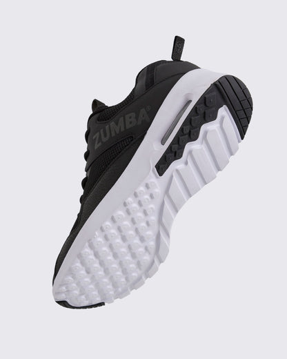 Black Zumba low-top athletic sneaker shown from the bottom angle, emphasizing the textured lug outsole, deep grooves, and visible air cushioning in the heel.
