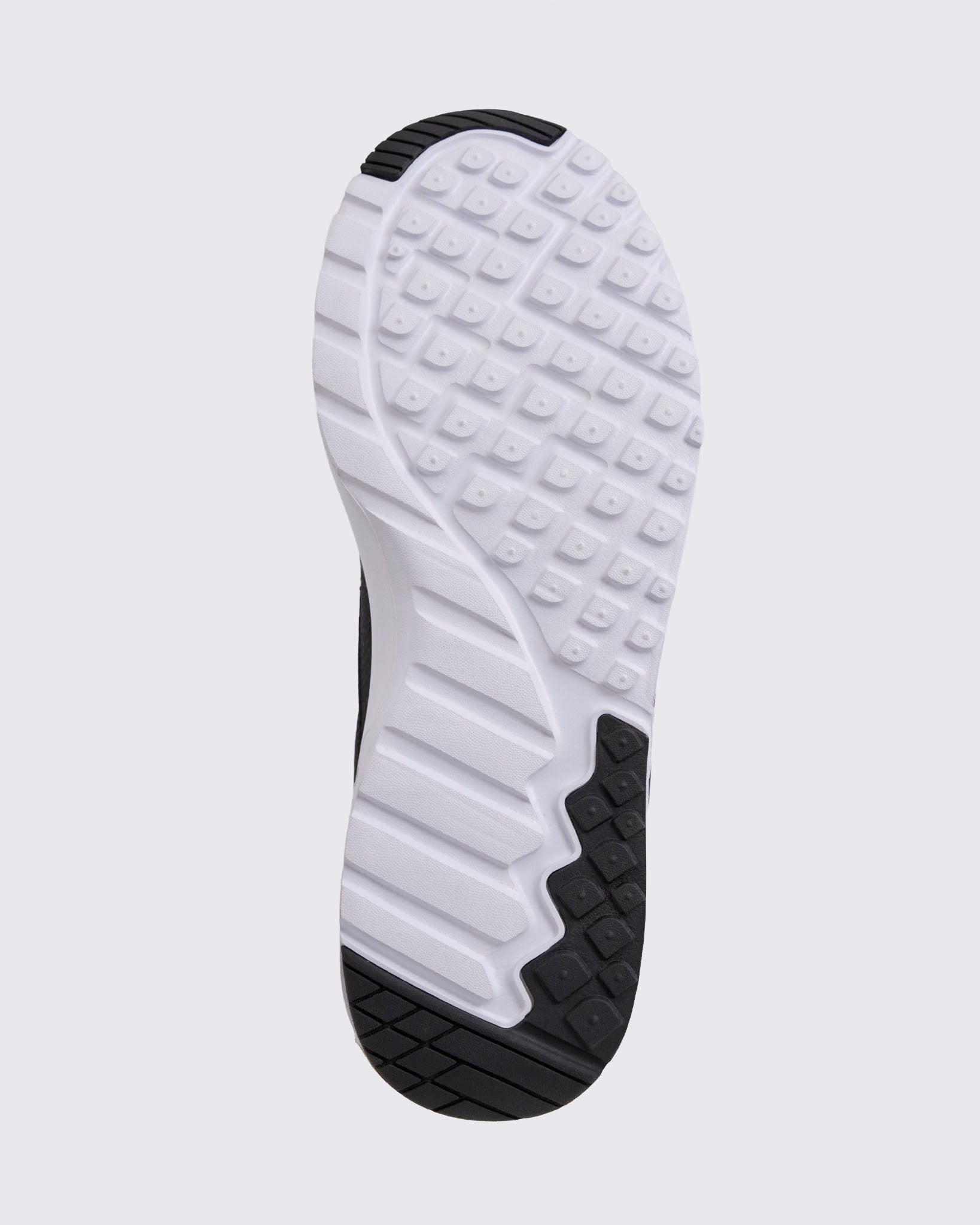 Black Zumba sneaker outsole view, highlighting the full tread pattern with square grip lugs, flex grooves, and black rubber traction zones.