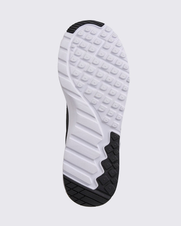 Black Zumba sneaker outsole view, highlighting the full tread pattern with square grip lugs, flex grooves, and black rubber traction zones.