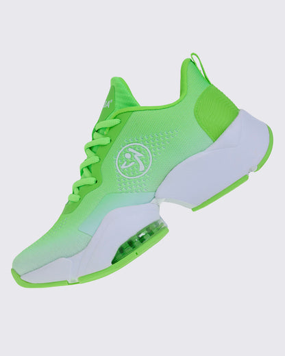 Left side view of a neon green sneaker tilted back, showing white "ZUMBA" text on the tongue and a white midsole.
