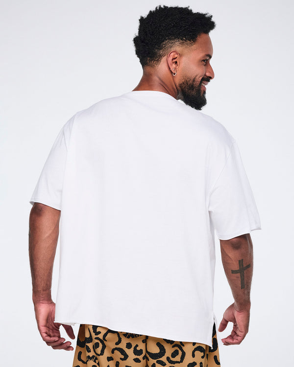 White oversized T-shirt, shown from the back on a smiling male model wearing tan leopard-print cargo pants.