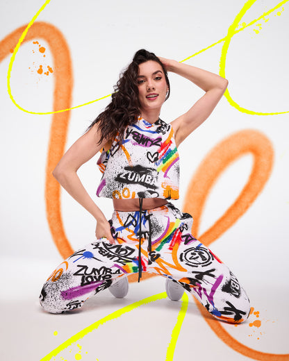 Female model wearing a colorful Zumba outfit with abstract designs on a white background.