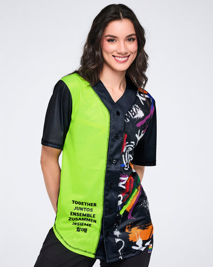 Female model wearing a neon green and black graphic Zumba jersey with multicolor accents on a white background.