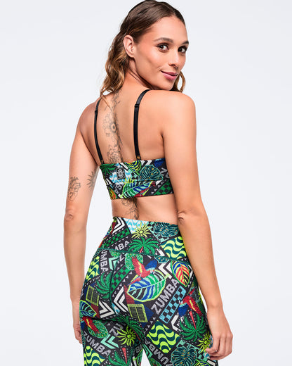 Back view of the tropical-print sports bra with adjustable black straps on a female model, paired with matching high-waisted tropical-print leggings on a white background.