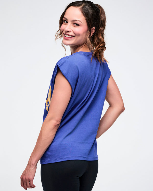 Back view of a female model in a blue shirt and black leggings on a white background.