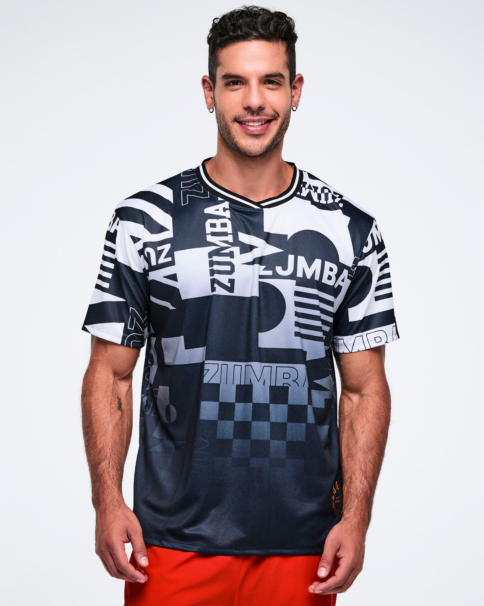 Male model wearing a black and white patterned Zumba shirt on a white background.