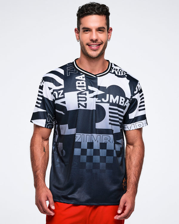 Male model wearing a black and white patterned Zumba shirt on a white background.