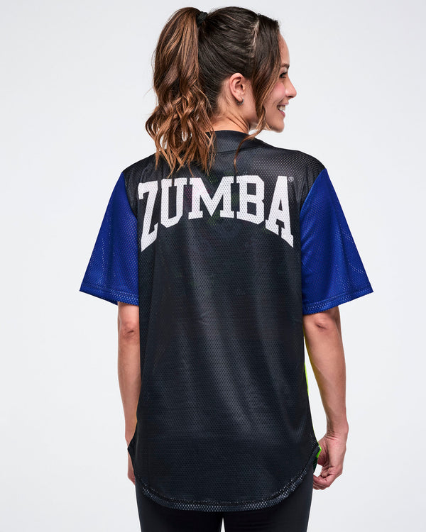 Back view of a female model wearing a black Zumba shirt with blue sleeves with 