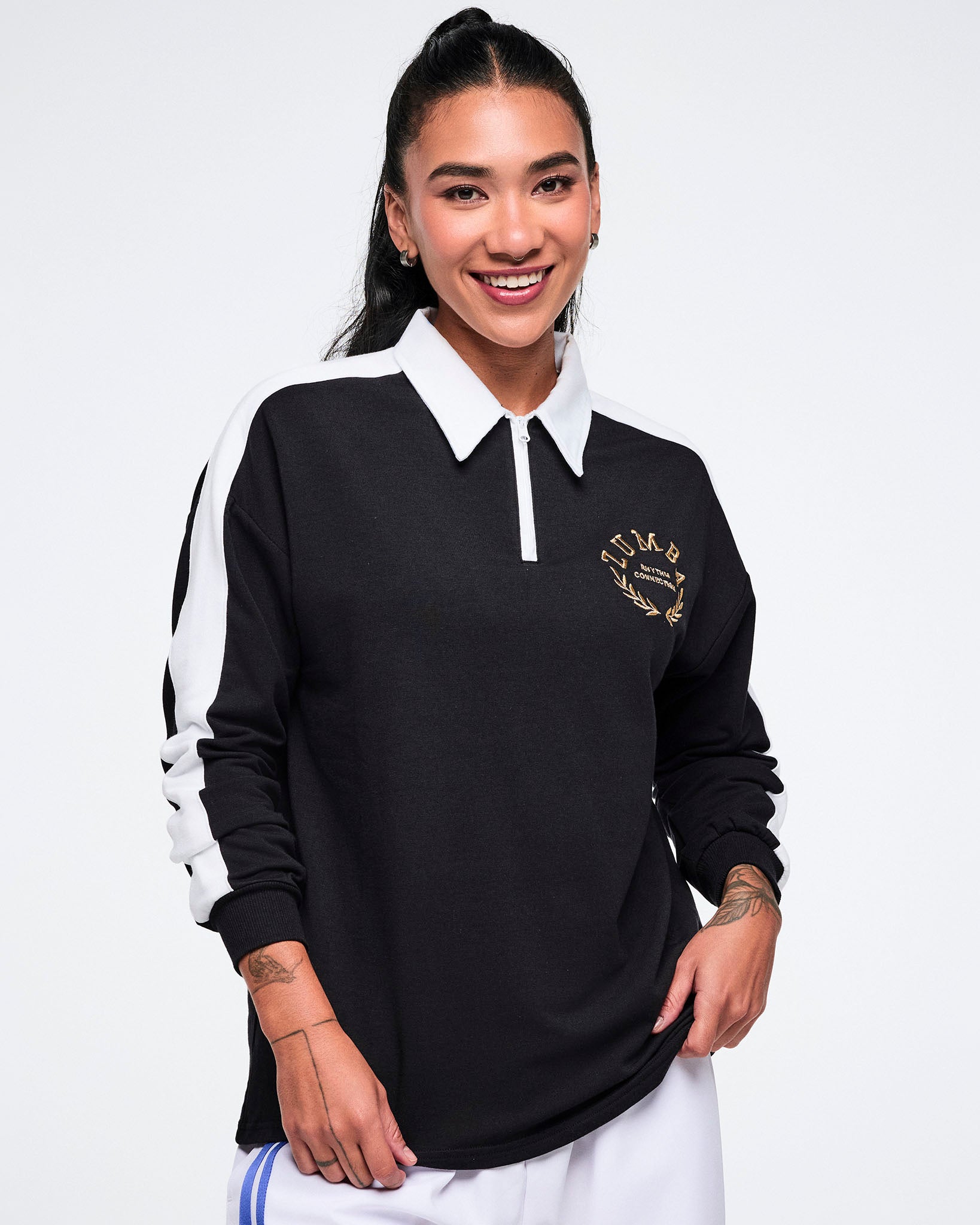 Female model wearing a black long-sleeve polo with a white collar and side stripes on a white background.