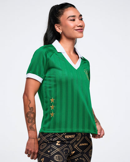 Right-side view of a female model in a green polo with white accents and three gold stars on a white background.