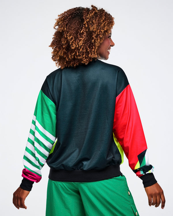 Back view of a female model wearing a black shirt with colorful sleeves on a white background.