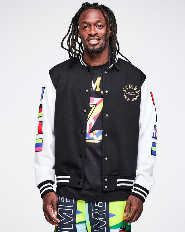 Male model wearing a black and white varsity jacket with colorful designs on a plain background.