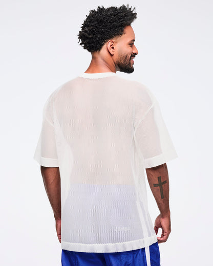 Back view of the white mesh short-sleeve V-neck top showing a sheer, breathable mesh texture, modeled by a male wearing blue track pants on a white studio background.