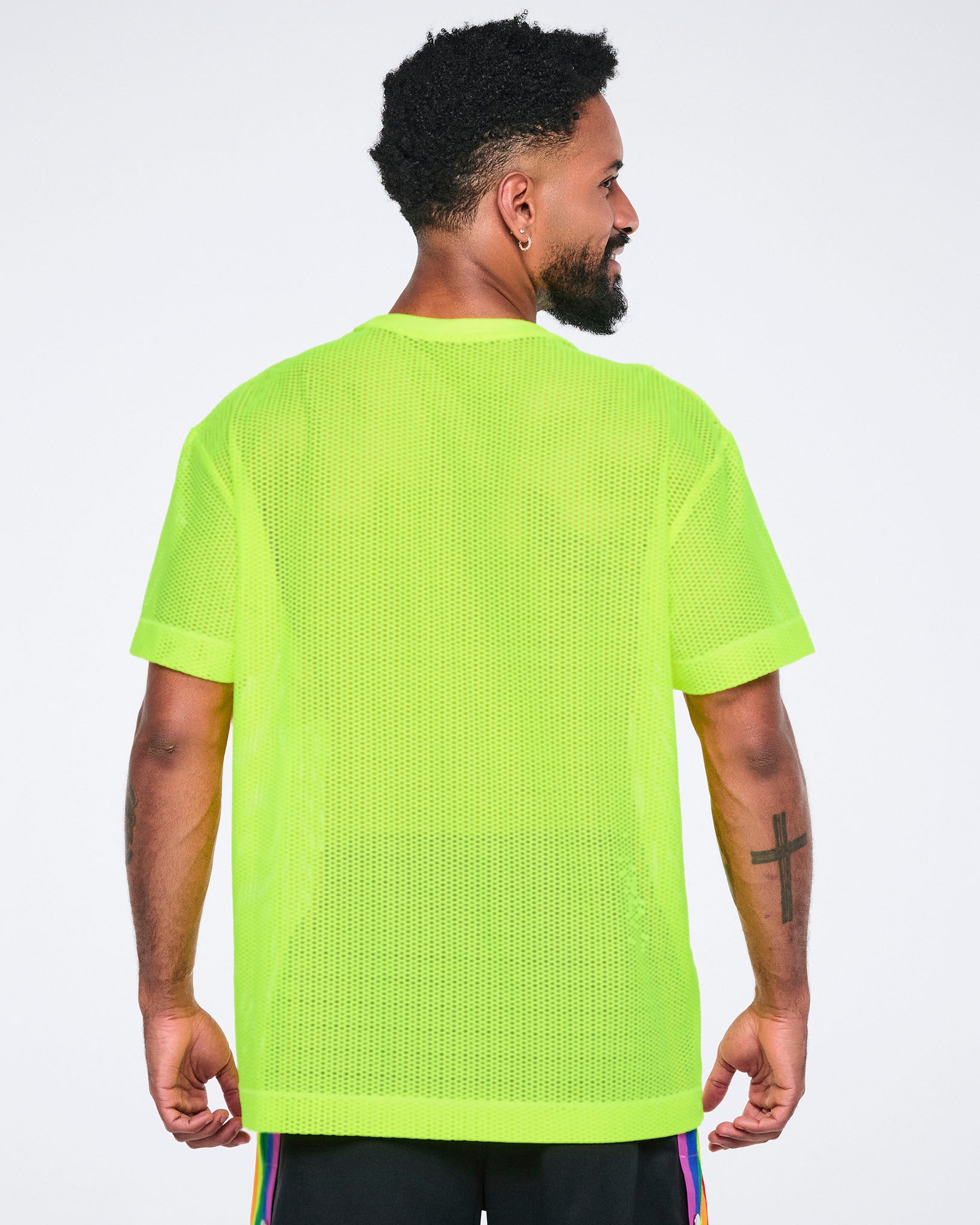 Back view of a male model wearing a bright yellow mesh top on a white background.